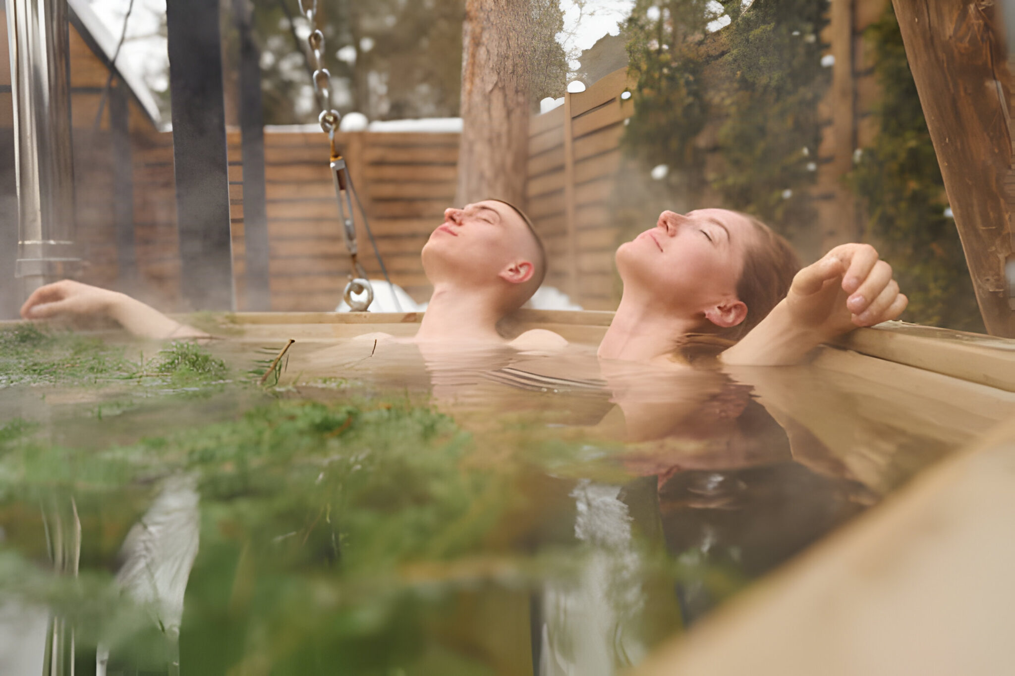 Couple enjoying a peaceful moment in a steamy outdoor hot tub in a snowy setting