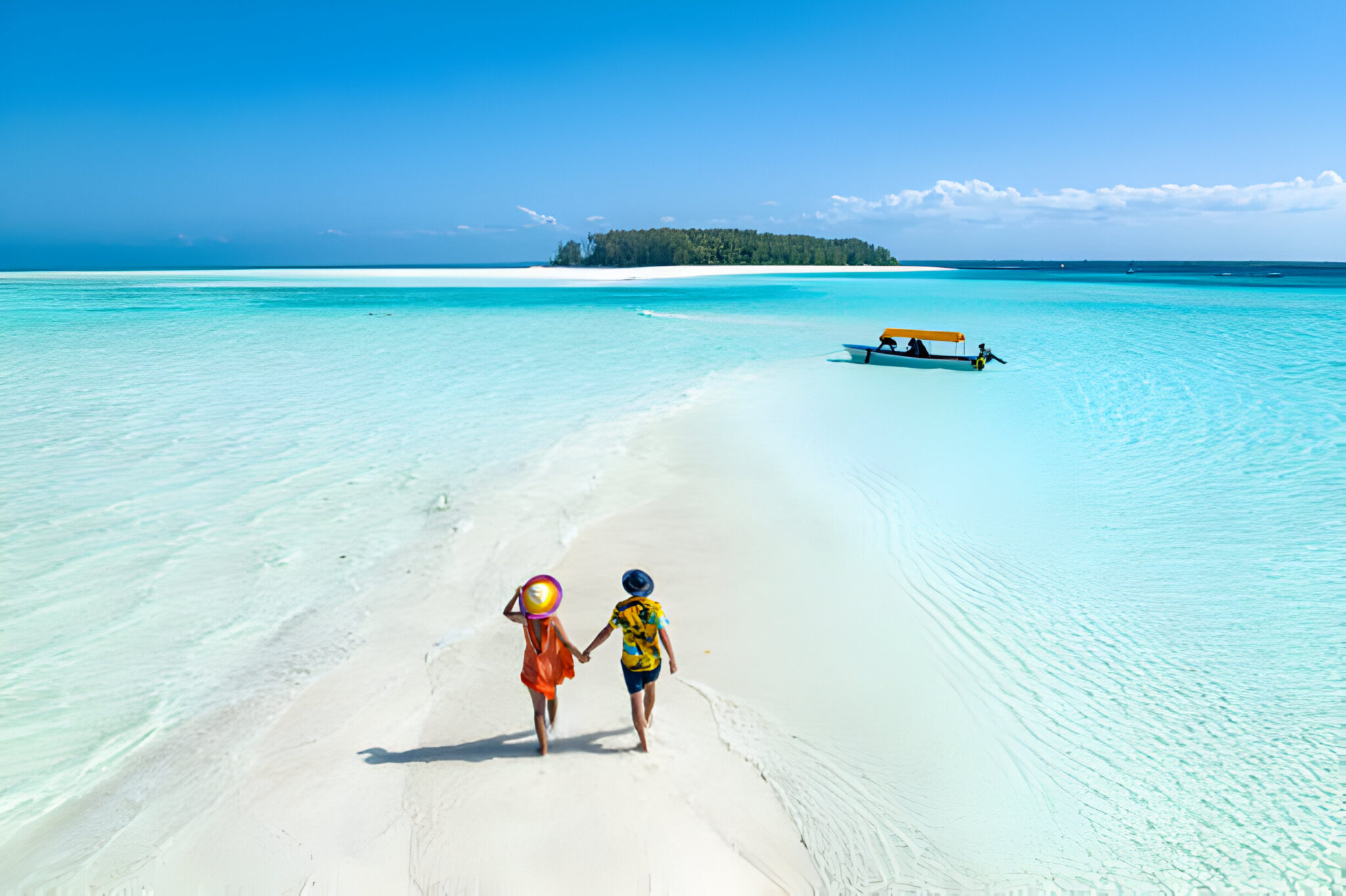 Overhead view of man and woman holding hands on idyllic beach